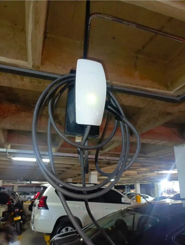 Cargador Tesla instalado en el techo de un parqueadero de edificio residencial en Bogotá