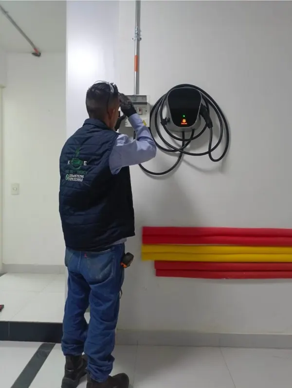Técnico de Kinetic Energy junto a cargador instalado en muro