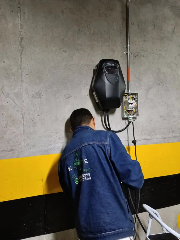 Técnico de Kinetic Energy conectando un cargador de vehículo eléctrico