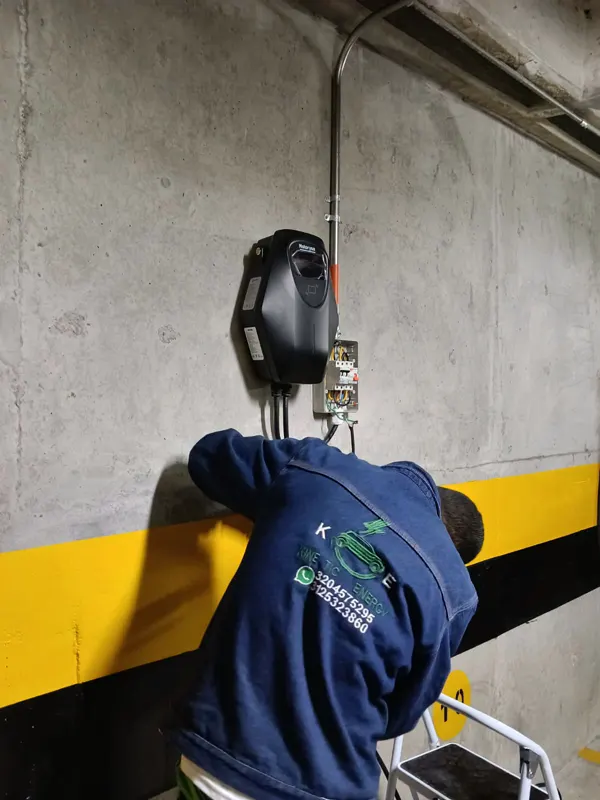 Técnico de Kinetic Energy montando cargador en sótano demarcado