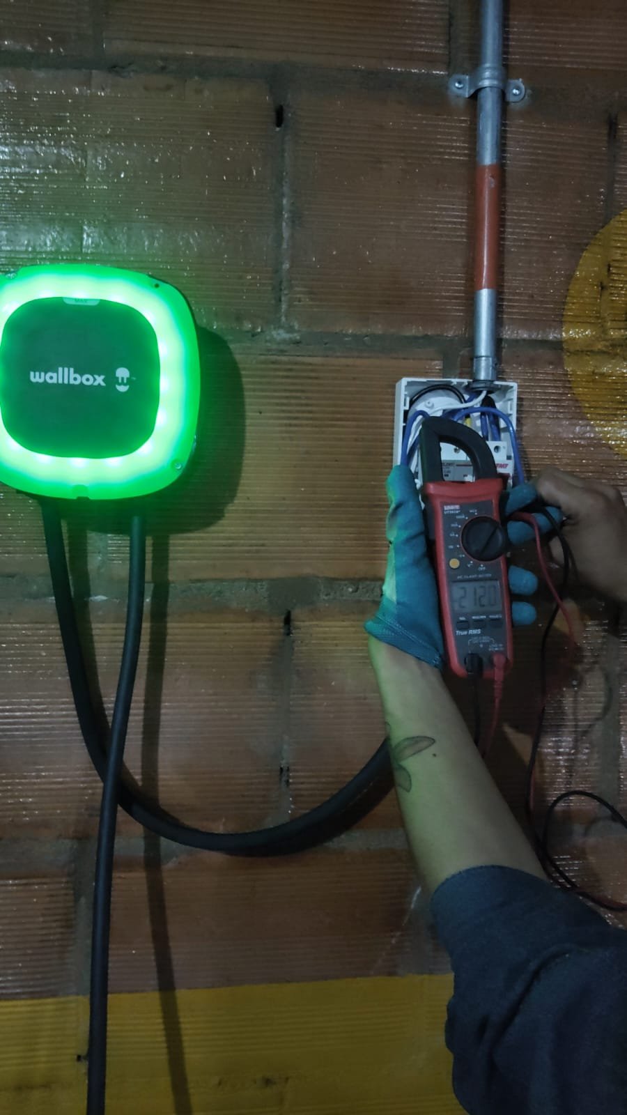 Medición de tensión con pinza amperimétrica sobre cargador Wallbox durante el estudio de análisis de carga