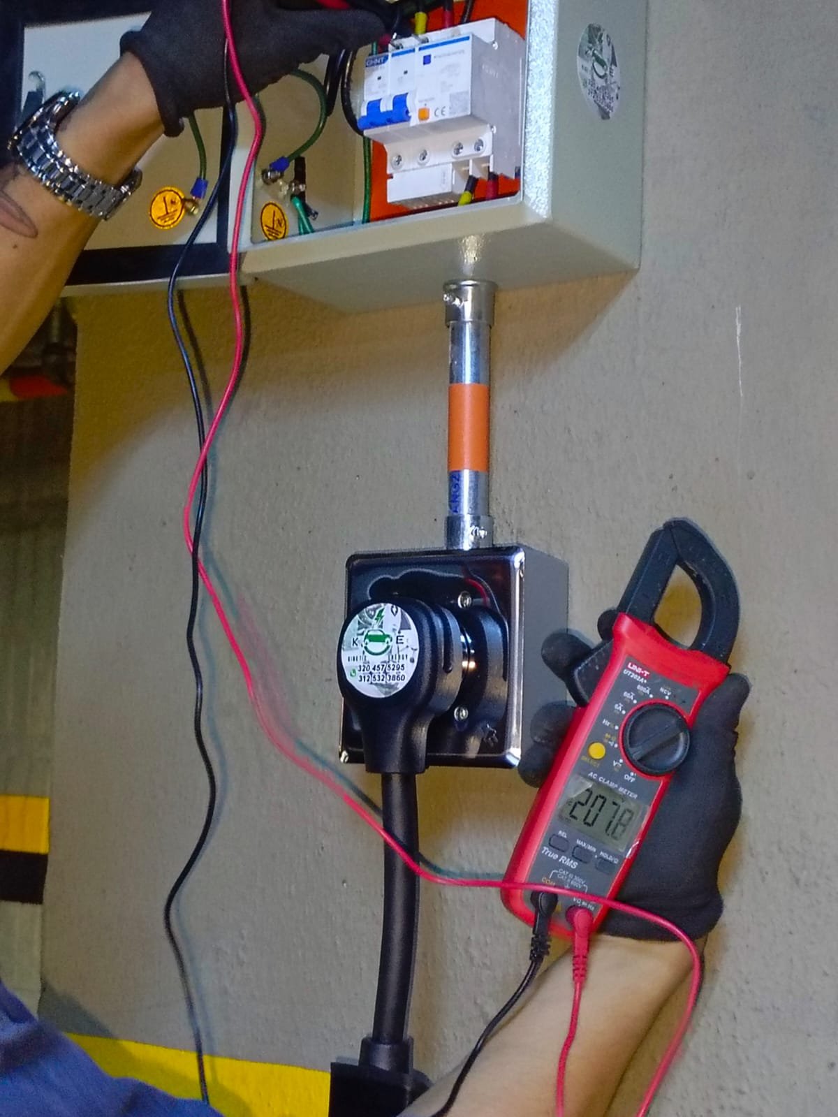 Técnico de Kinetic Energy midiendo la carga eléctrica con pinza amperimétrica en el tablero de un conjunto residencial